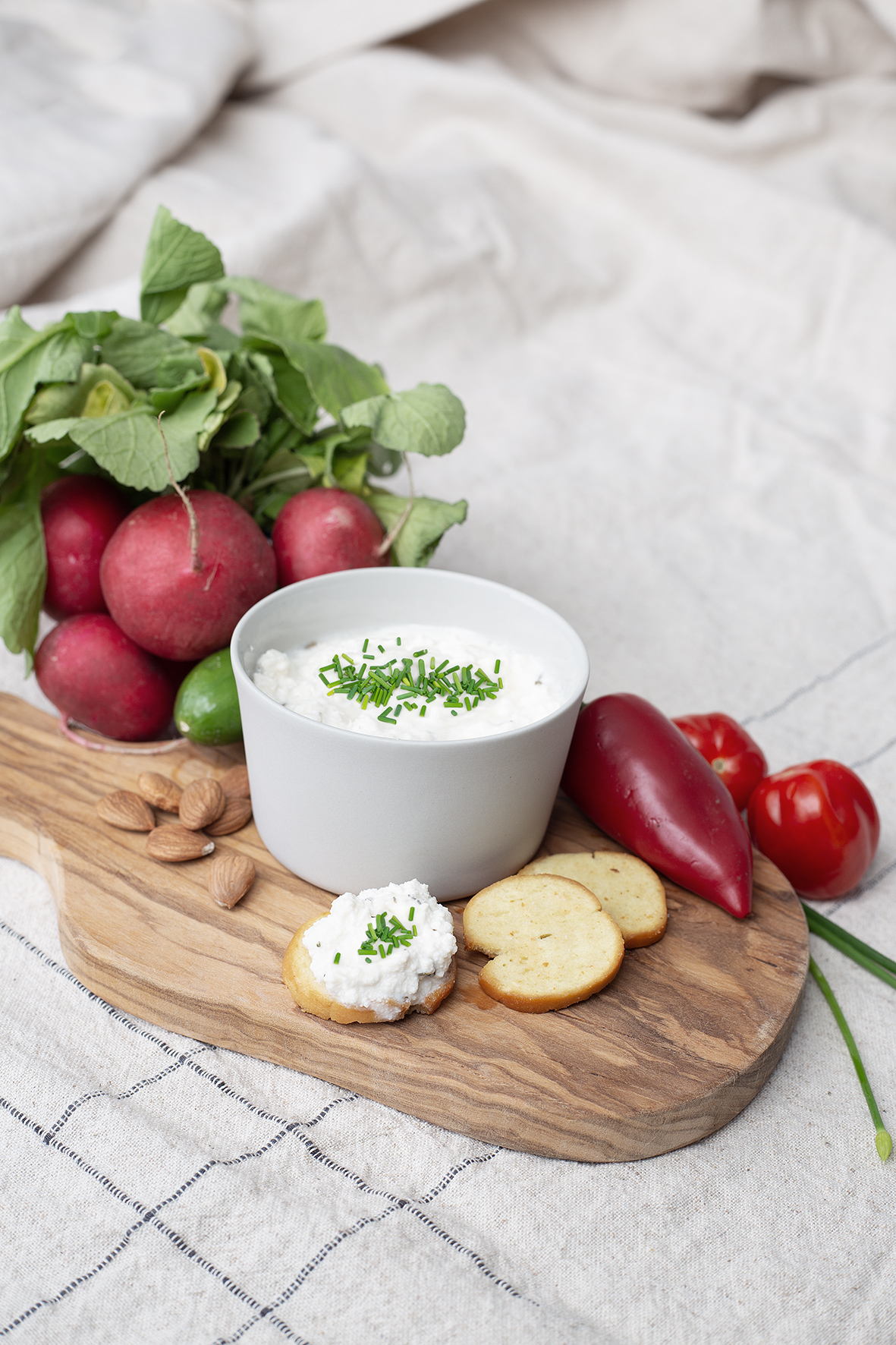 Jausebrett auf einem Tisch angerichtet mit pflanzlichem Hüttenkäse.
