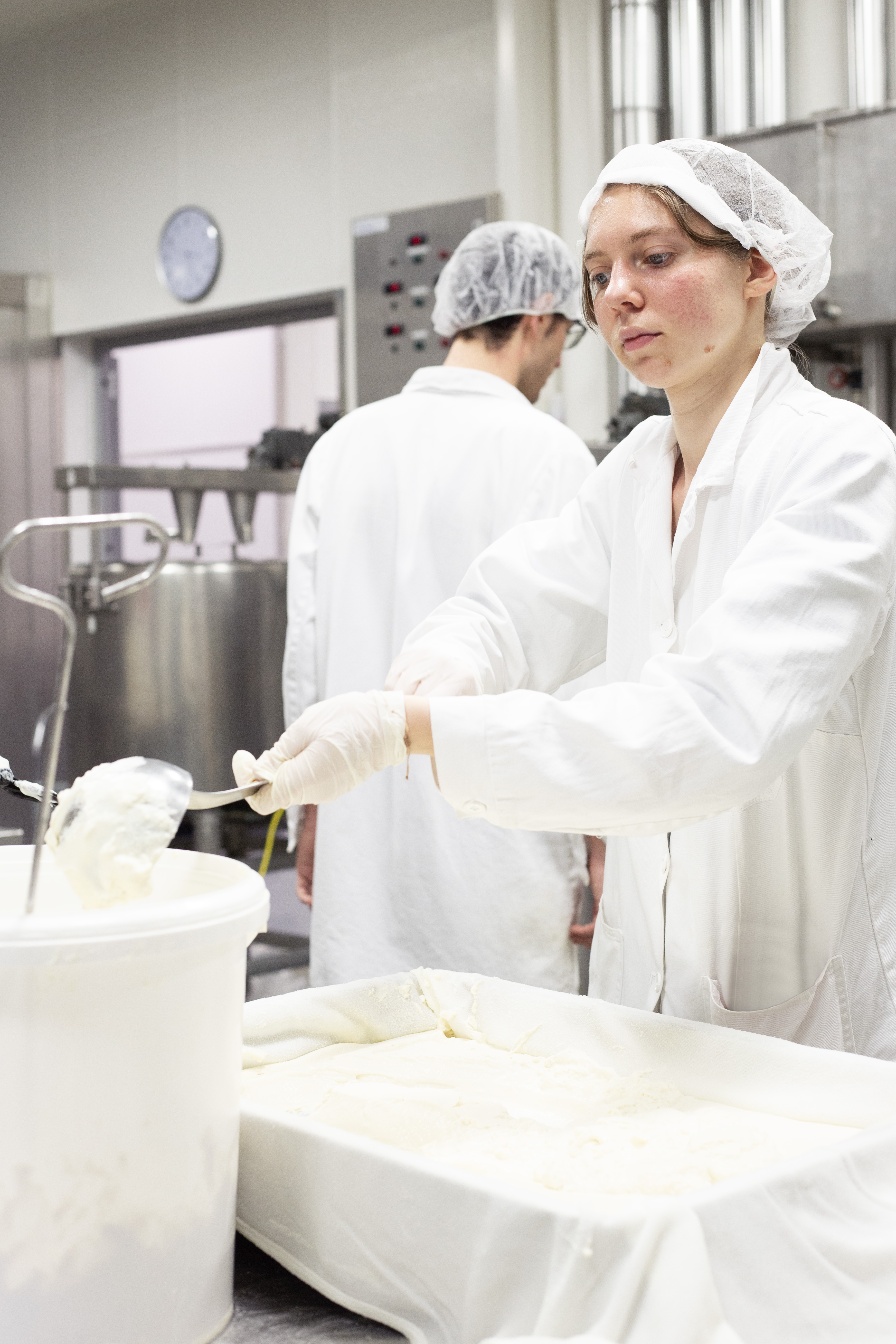 Frau stellt pflanzlichen Käse in der Molkerei her.